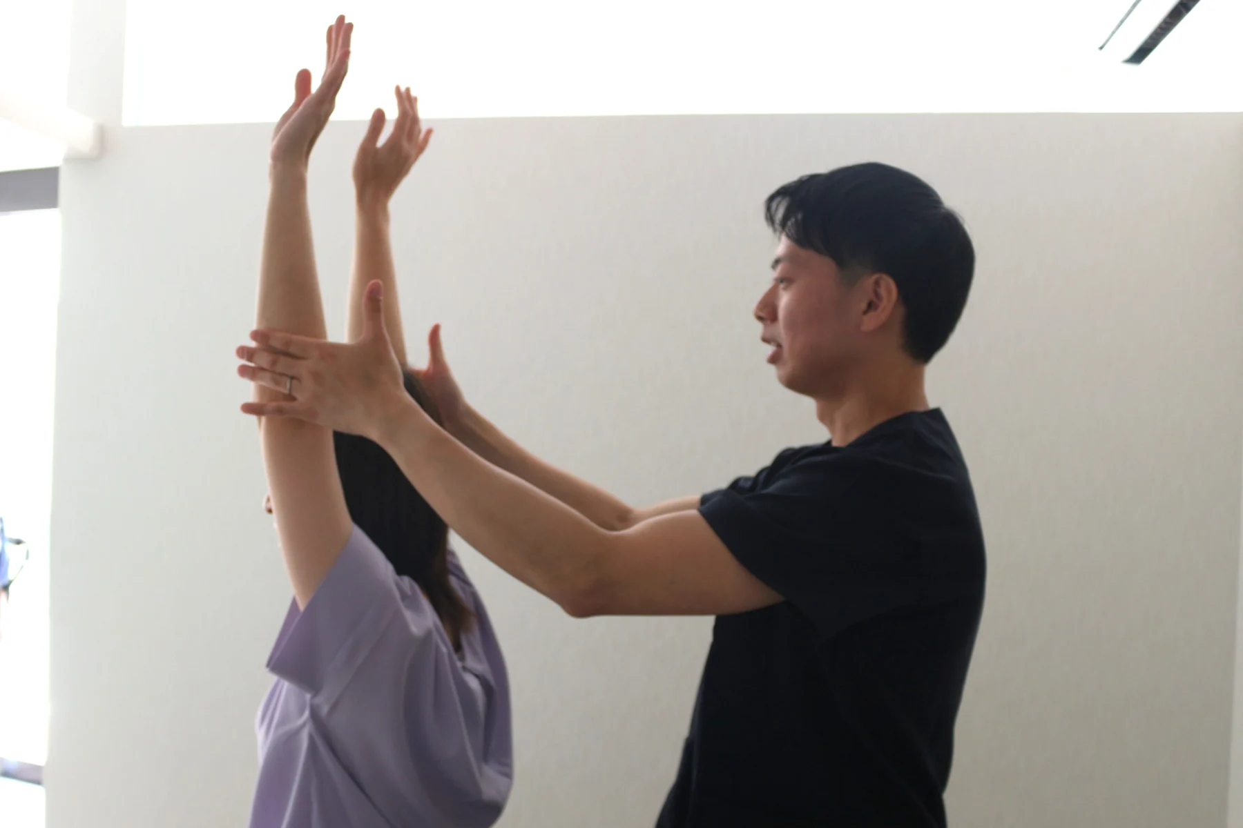 腕を上げる動きを確認する様子